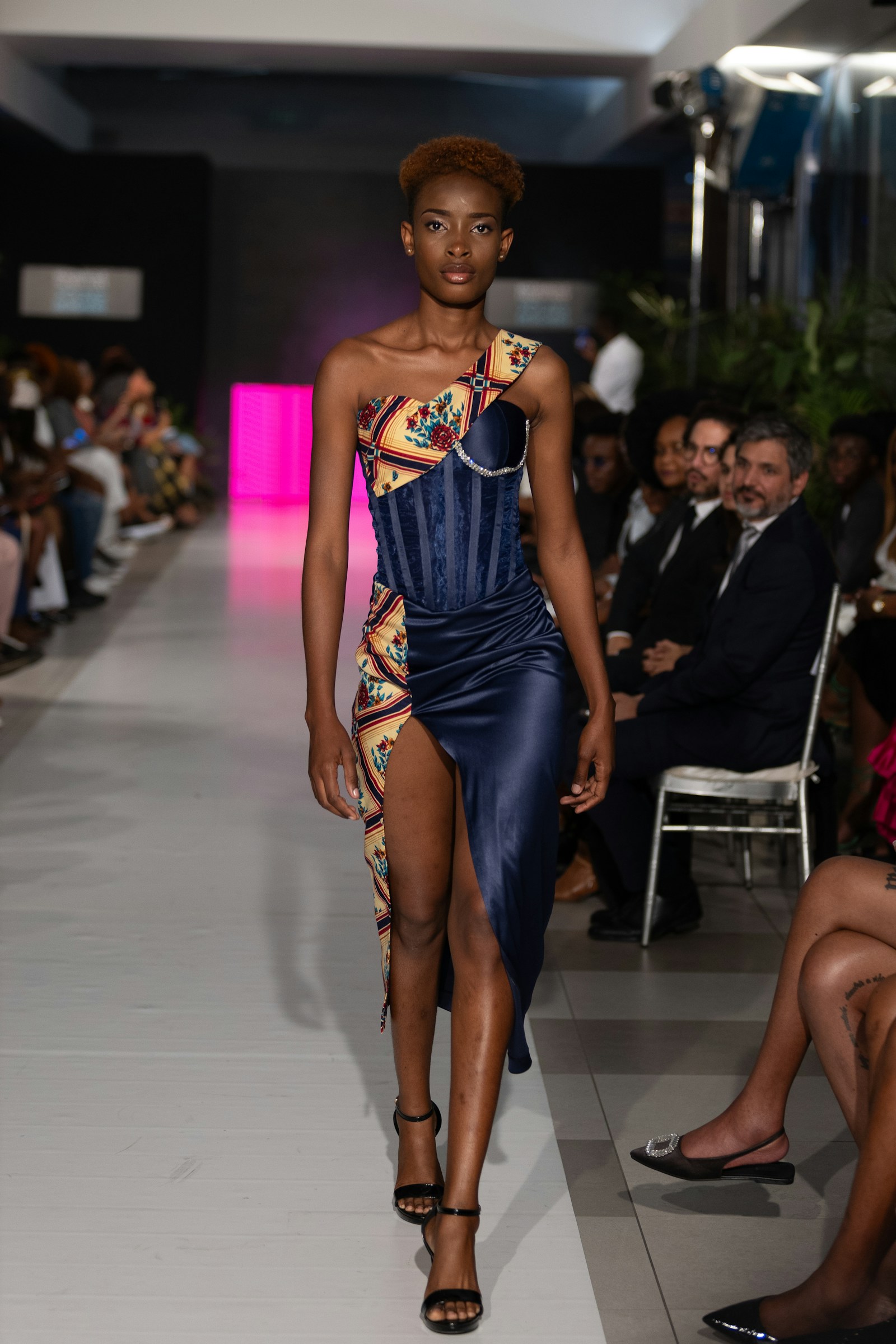 A model presenting a detailed dress on the runway