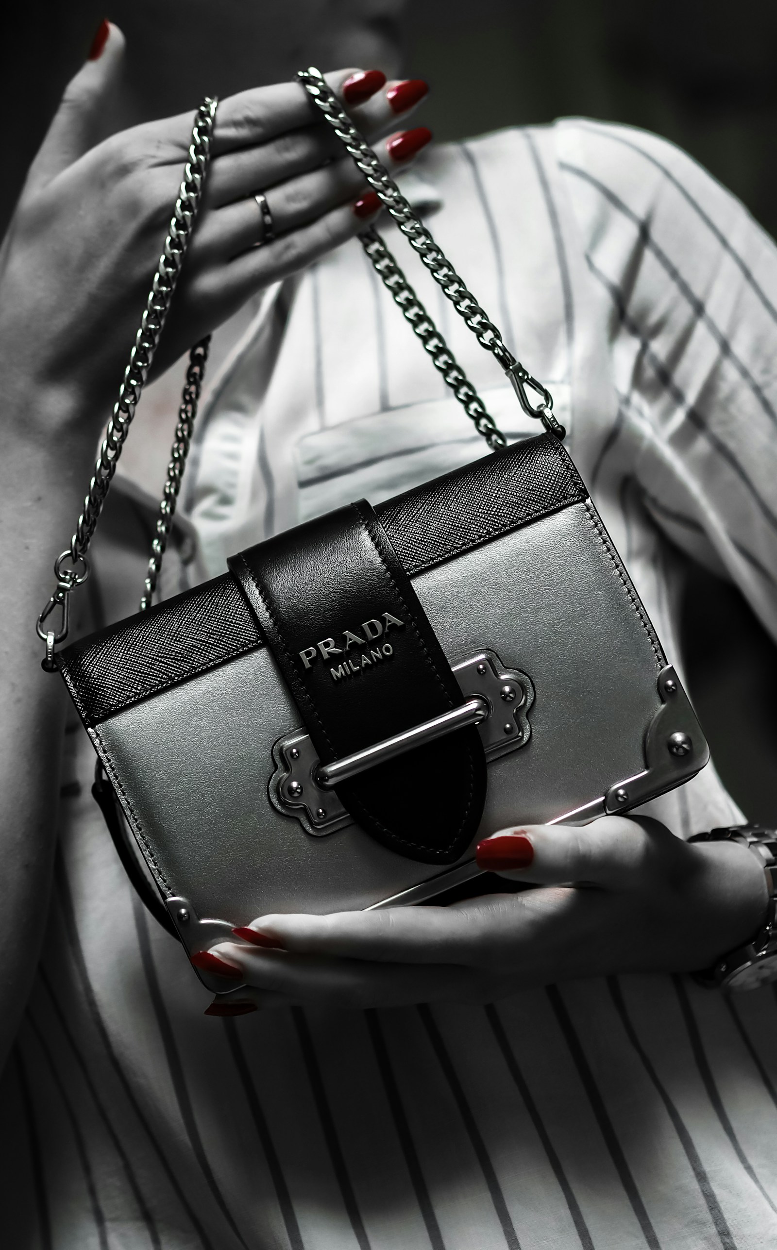 Black Prada handbag photographed against tailored white fabric