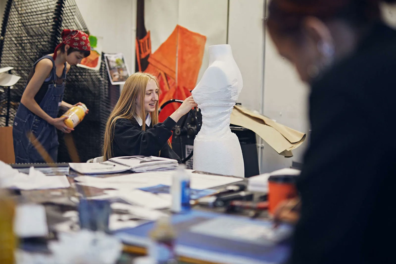 Fashion students working on a mannequin in a design studio